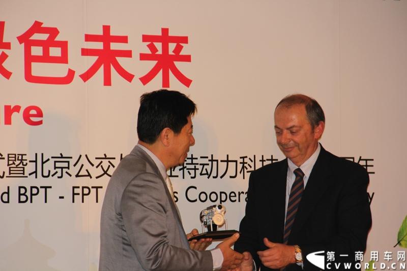 6月24日，菲亚特动力科技（FPT）与北京公交集团的天然气发动机供货交接仪式在意大利驻华大使馆隆重举行。时值双方合作十周年之际，菲亚特动力科技再次为北京公交集团提供了将近1200台环保型天然气发动机。图为菲亚特动力科技向北京公交集团赠送发动机模型。