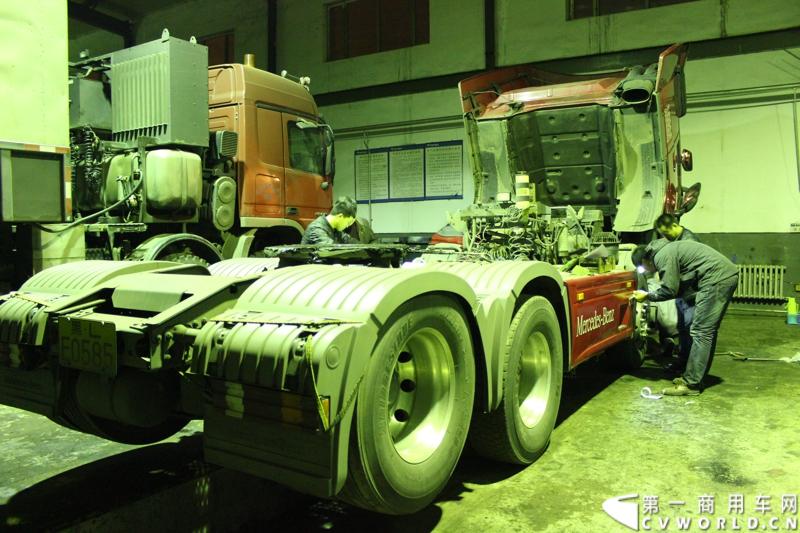 临行前夜，在梅赛德斯-奔驰卡车（中国）有限公司哈尔滨市奔驰卡车4S店内，一行工作人员为车辆进行检测维修，并贴上本次西藏之行的标语爱心企业标识。