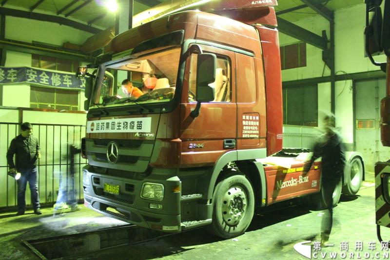 临行前夜，在梅赛德斯-奔驰卡车（中国）有限公司哈尔滨市奔驰卡车4S店内，一行工作人员为车辆进行检测维修，并贴上本次西藏之行的标语爱心企业标识。