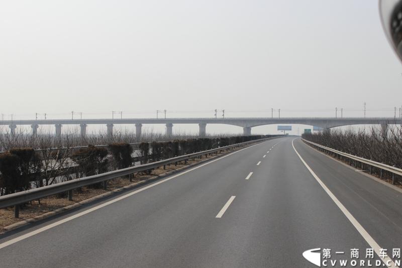 在山海关服务区稍作休整后，奔驰卡车继续南下。图为北京至广州的高速铁路铁架桥。