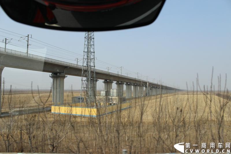在山海关服务区稍作休整后，奔驰卡车继续南下。图为北京至广州的高速铁路铁架桥。