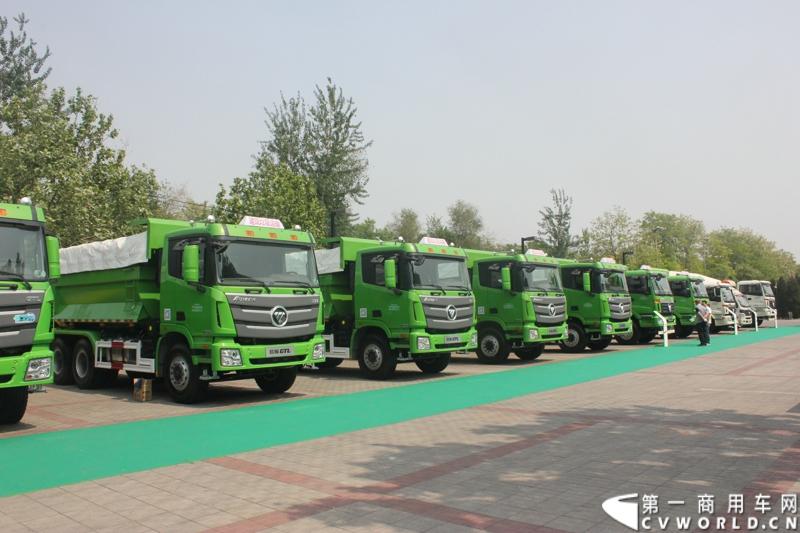 4月29日，福田戴姆勒汽车在北京举办以“清洁首都空气 开启绿色渣运”为主题的新一代智能环保渣土车首批交车仪式。活动现场，福田戴姆勒汽车首批交付共计300辆第三代智能渣土车，，在北京市政府的牵线下，北京建工集团、北京城建集团、北京轨道集团与首批置换新型渣土车的北京利达金路腾、北京成伟兄弟、北京富鑫、北京丰台南宫等土石方运输公司签订了渣土承运合同。图为交车仪式现场展示的欧曼第三代智能渣土车。