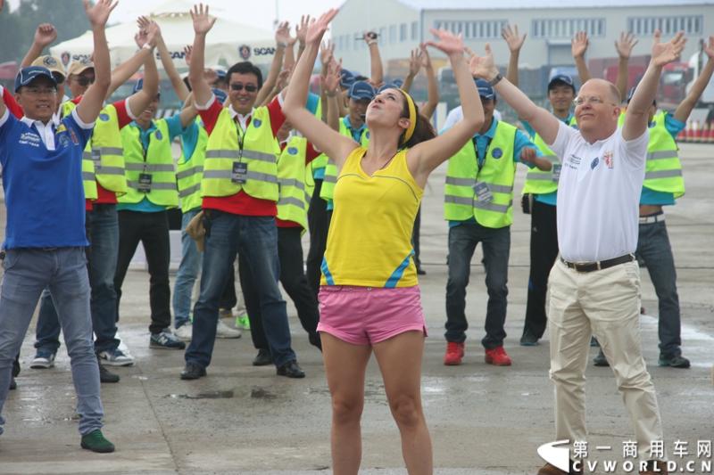 7月13日，“2014斯堪尼亚中国卡车驾驶员大赛”在冰城哈尔滨开战。现场突如其来的暴雨并没有影响参赛者们的热情与激情，紧张激烈的比赛氛围贯穿全场。最终，经过紧张的角逐，来自天津东粮欣瑞物流有限公司的刘健问鼎冠军。图为赛前动感热身。