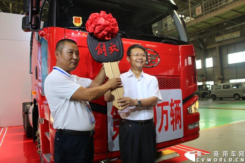 2014年7月15日，一汽解放迎来61年华诞。以“传承 传奇 传递梦想”为主题的一汽解放第600万辆卡车下线庆典暨解放国Ⅳ第5万辆交车仪式，在一汽解放长春基地世界级总装线举行。图为一汽集团公司副总经理秦焕明将代表解放国Ⅳ第5万辆卡车的金钥匙交给吉林省解放大用户朴文星。