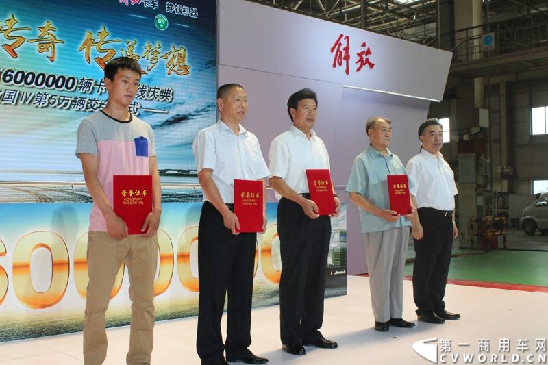 2014年7月15日，一汽解放迎来61年华诞。以“传承 传奇 传递梦想”为主题的一汽解放第600万辆卡车下线庆典暨解放国Ⅳ第5万辆交车仪式，在一汽解放长春基地世界级总装线举行。图为共和国第一代解放车老司机于丰年（右二）、解放功勋用户李进楼（中）、解放大用户李焕福父子（左二、左一）代表解放600万用户，接受一汽集团和解放公司的表彰。