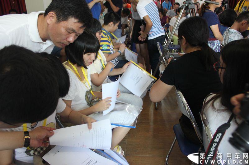 8月24日，福州康驰新巴士有限责任公司（简称康驰公司）旗下的8条“5i84”定制校车线路正式开通仪式在康驰公司齐安停车场举行。据介绍，康驰公司采购了9辆全新的宇通校车，一共开通了8条定制校车线路。图为向同学们派发校车服务协议